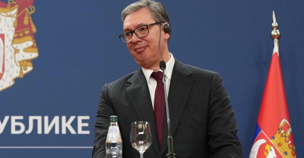 Aleksandar Vučić bei einer Pressekonferenz vor serbischer Flagge
