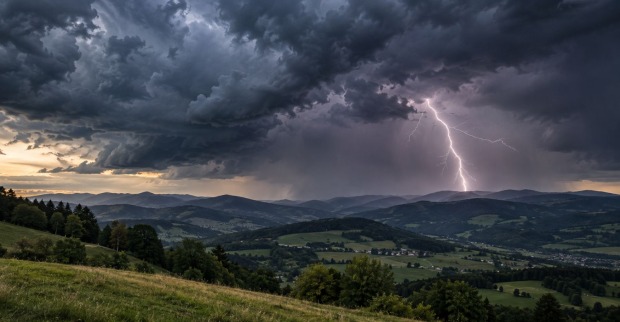 Dunkle Gewitterwolken ziehen über eine österreichische Berglandschaft