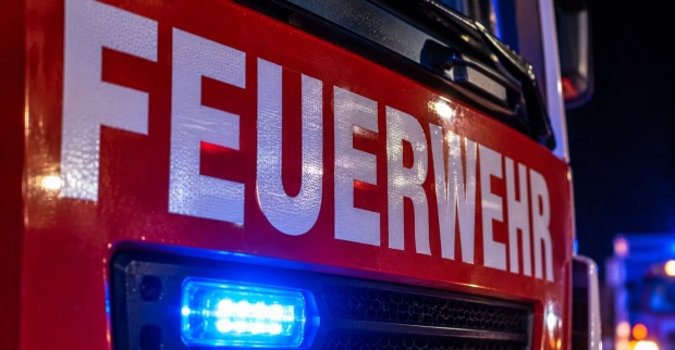 Feuerwehrfahrzeug mit Blaulicht bei einem nächtlichen Einsatz, Symbolbild