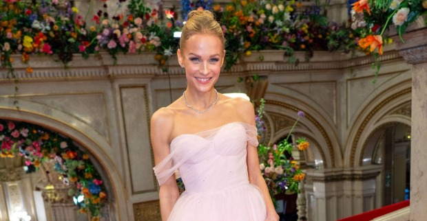 Mirjam Weichselbraun lächelt in einem eleganten rosa Kleid beim Wiener Opernball.
