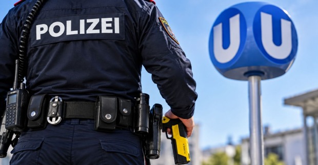 Polizist mit einem Taser in der Hand bei einer Wiener U-Bahnstation