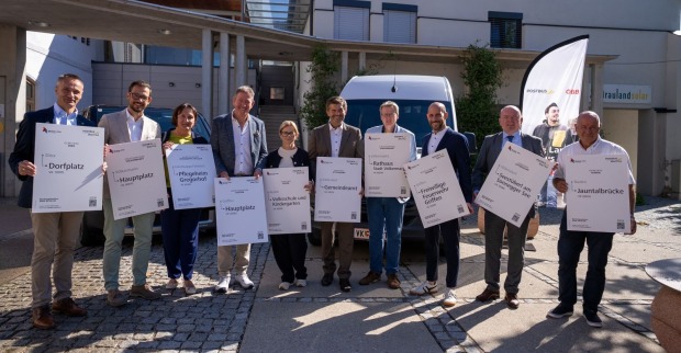 Vertreter der sechs Gemeinden präsentieren Haltepunkte des neuen Postbus Shuttle Völkermarkt vor den Shuttle-Fahrzeugen.