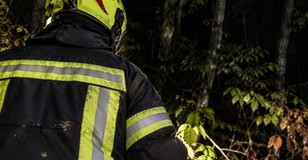 Feuerwehrmann bei Nacht in einem Wald als Symbolbild für den Unfall im Zillertal