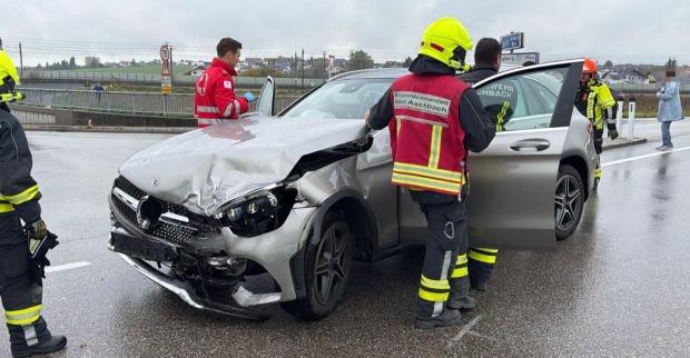 Unfall Aschbach auf der B122: Feuerwehrleute und Rettungskräfte stehen neben einem schwer beschädigten silbernen Mercedes an der Unfallstelle.