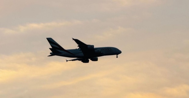 Flugzeug im Landeanflug bei Sonnenuntergang als Symbolbild für Reisen und Online-Buchungen über Booking.com.