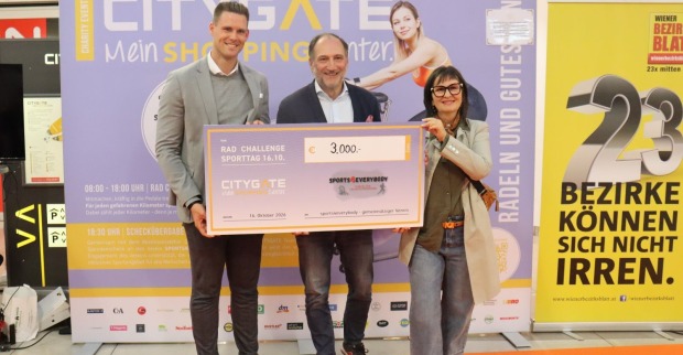 Drei Personen halten im Citygate Shopping einen großen Spendenscheck in Händen