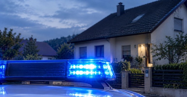 Eingeschaltete Sirene eines österreichischen Polizeiwagens vor einem Haus