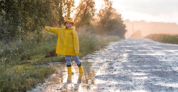 Ein Junge mit gelber Jacke bei Herbstwetter.