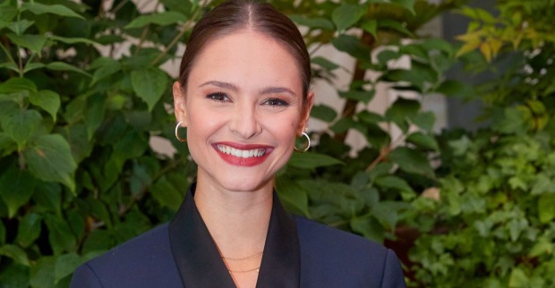 Puls 4-Moderatorin Julia Furdea lächelt in einem dunklen Blazer in die Kamera. In einem Interview spricht sie offen über Zweifel und ihre TV-Anfänge.