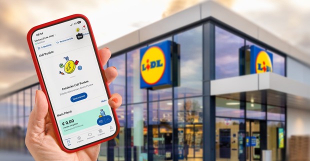 Außenansicht einer Lidl-Filiale mit einem Smartphone auf dem die Lidl Plus App installiert ist