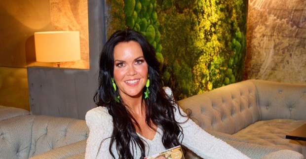 Martina Reuter sitzt lächelnd auf einem Sofa und trägt einen hellen Pullover. Die ehemalige ORF-Moderatorin bereitet sich auf ihren nächsten Bodybuilding-Wettkampf vor.