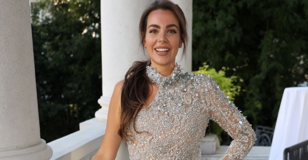 Nadine Mirada posiert lächelnd in einem funkelnden silbernen Kleid. Das österreichische Model verkündet einen neuen Agenturvertrag in New York.