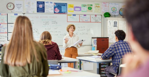 Lehrerin steht in einer Klasse und unterrichtet