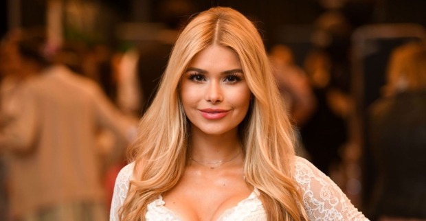Fitness-Influencerin Pamela Reif mit langen blonden Haaren und weißem Spitzenoberteil bei einem öffentlichen Event
