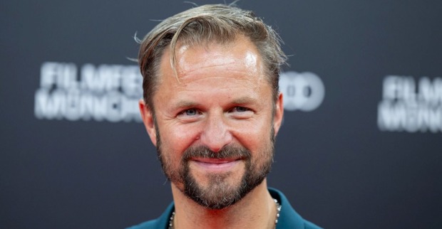 Philipp Hochmair lächelt bei einem öffentlichen Auftritt in die Kamera. Der österreichische Schauspieler feiert mit „Jedermann Reloaded“ einen großen Erfolg in Hamburg.