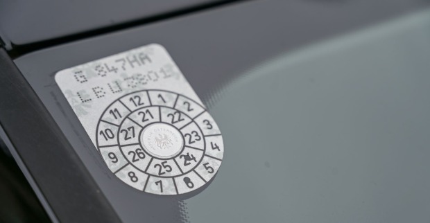 Das sogenannte Pickerl, die Prüfplakette, in einer Fensterscheibe eines österreichischen Pkw