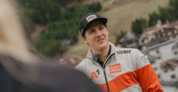 Raphael Haaser lächelt im ÖSV-Dress mit seiner neuen Sponsorenkappe