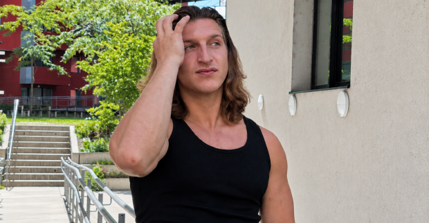Influencer Satans Bratan, bürgerlich Erik Seidl, mit langen Haaren und schwarzem Tanktop im Freien. Sein neues Instagram-Ekel-Video sorgt für Aufsehen.