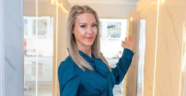 Simone Lugner, Witwe von Richard Lugner und Teilnehmerin bei „Forsthaus Rampensau“, posiert in einer blauen Bluse und lächelt in die Kamera.