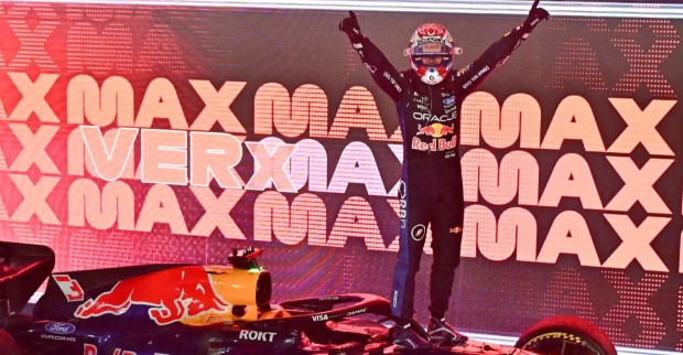 Max Verstappen im Red-Bull-Rennanzug mit erhobenen Armen auf seinem Formel-1-Boliden nach dem Sieg beim Großen Preis von Singapur 2026.