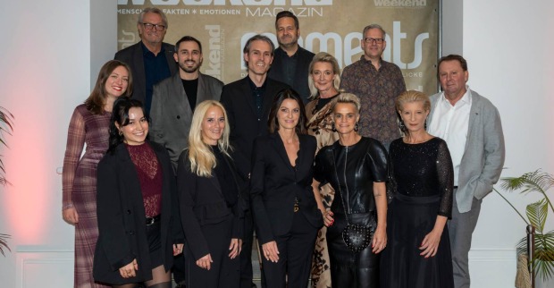 Das Team des Weekend Magazin Steiermark vor einer Fotowand auf Schloss Vasoldsberg anlässlich seiner 20. Geburstagsfeier