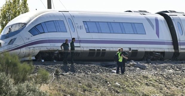 Beschädigter spanischer AVE-Hochgeschwindigkeitszug auf Bahngleisen, mehrere Einsatzkräfte untersuchen den Zug.