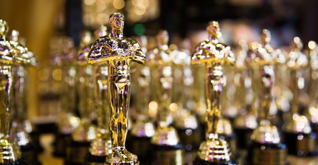 Mehrere Oscar-Statuetten auf einem Glastisch