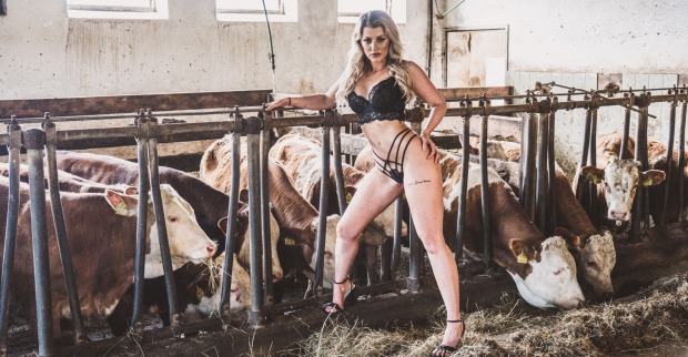 Junge Frau in einem Stall mit Kühen