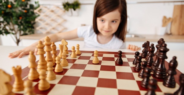 Kleines Mädchen spielt meisterhaft Schach | Credit: iStock.com/yacobchuk