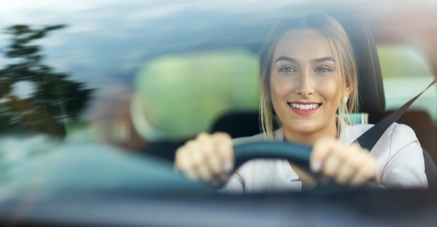 Frau lächelt beim Autofahren | Credit: iStock.com/PIKSEL
