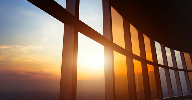 Glasfassade eines Hochhauses bei Sonnenaufgang | Credit: iStock.com/anyaberkut