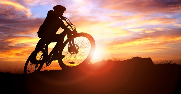 Mountainbike-Fahrer fährt bei Sonnenuntergang | Credit: iStock.com/BrianAJackson