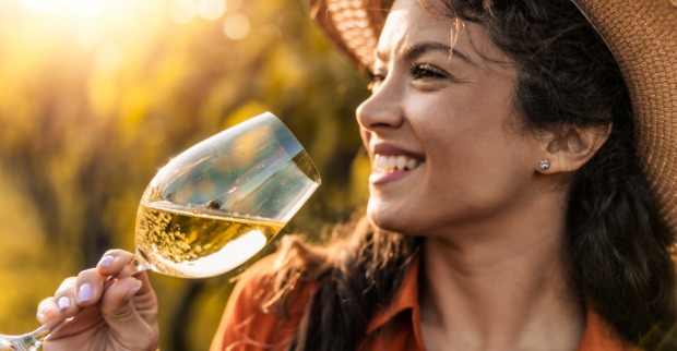 Junge Frau genießt ein Glas Weißwein | Credit: iStock.com/Ivanko_Brnjakovic