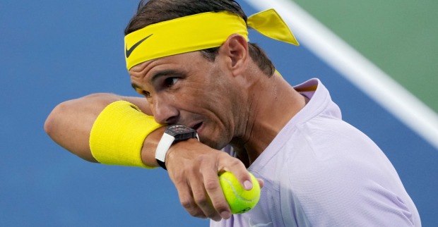 Rafael Nadal wischt sich sein Gesicht am Schweißband ab.