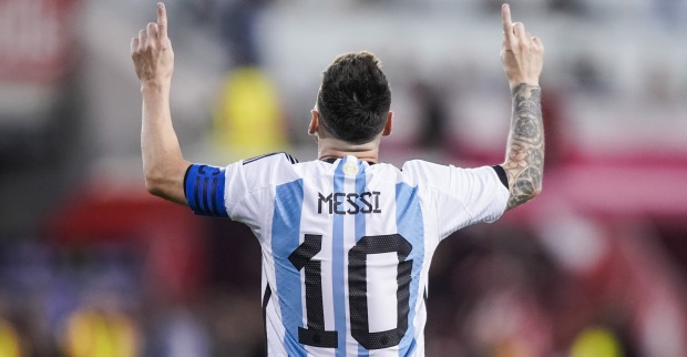 Rückenansicht von Lionel Messi im Dress der argentinischen Nationalmannschaft, der mit beiden Zeigefingern himmelwärts deutet