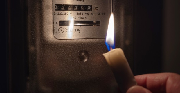 Blackout: Mit Kerze wird Stromzähler gecheckt. | Credit: iStock.com/Evgen_Prozhyrko