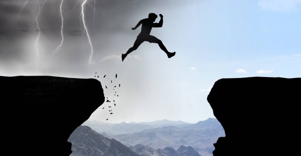 Mann überwindet springend einen Abgrund | Credit: iStock.com/Bastian Weltjen