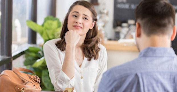 Eine junge Frau schaut skeptisch bei einem Date