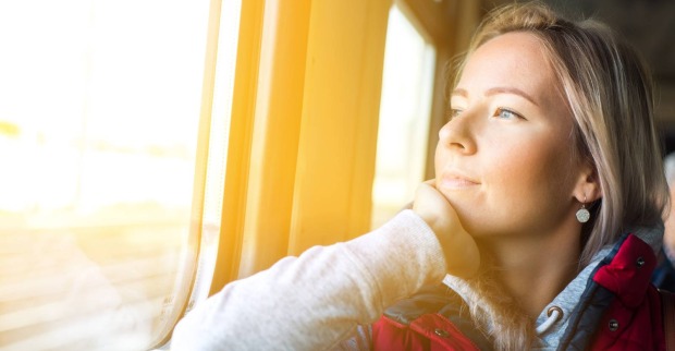 Frau blickt während der Zugfahrt aus dem Fenster | Credit: iStock.com/ALFSnaiper
