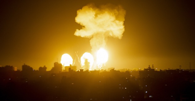 Aufnahme einer Stadt bei Nacht vor dem Hintergrund mehrerer Explosionen und einer gigantischen Rauchsäule