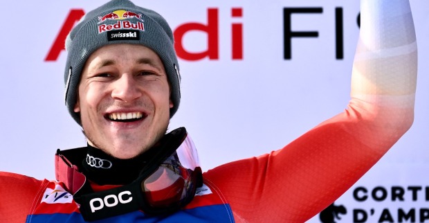 Der Schweizer Skiprofi Marco Odermatt in Siegerpose bei der Siegerehrung in Cortina d'Ampezzo
